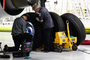 Aircraft mechanics changing a tire